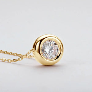 Gold solitaire pendant necklace with bezel-set diamond on a fine chain.