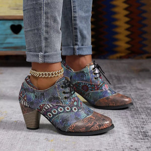 Floral patchwork lace-up ankle boots with a block heel and intricate embossed patterns.