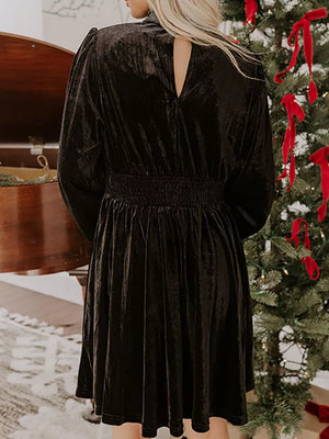 Black velvet mock neck dress with smocked waist and balloon sleeves.