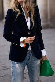 Navy velvet bolero jacket with gold buttons, styled with a white shirt and distressed jeans.