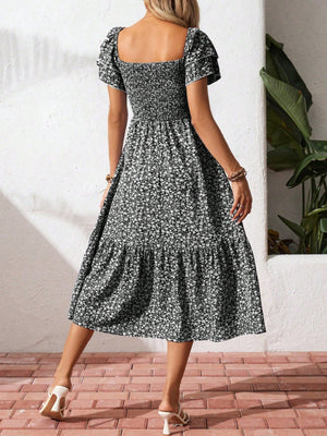 Black floral smocked midi dress with ruffle sleeves and tiered skirt.
