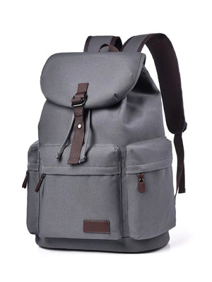 Gray canvas backpack with brown leather accents and multiple pockets.