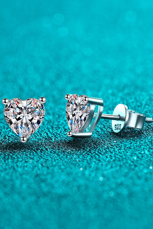 Silver heart-cut moissanite stud earrings with a sparkling diamond-like center.