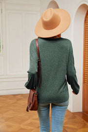 Green relaxed knit sweater with lace trim detail and V-neck, styled with jeans and a hat.