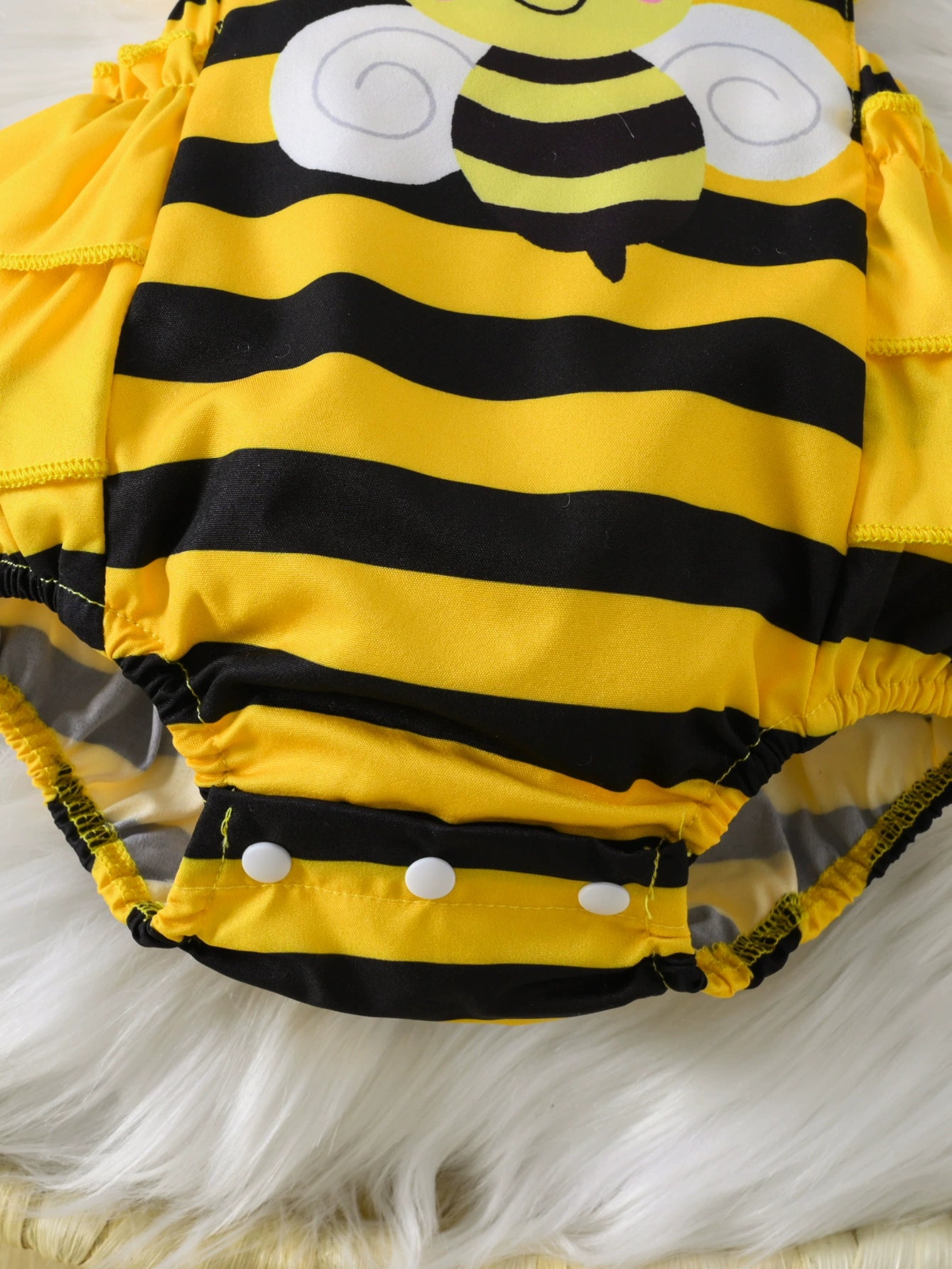 Baby bee striped bodysuit dress with ruffles and snap closure.