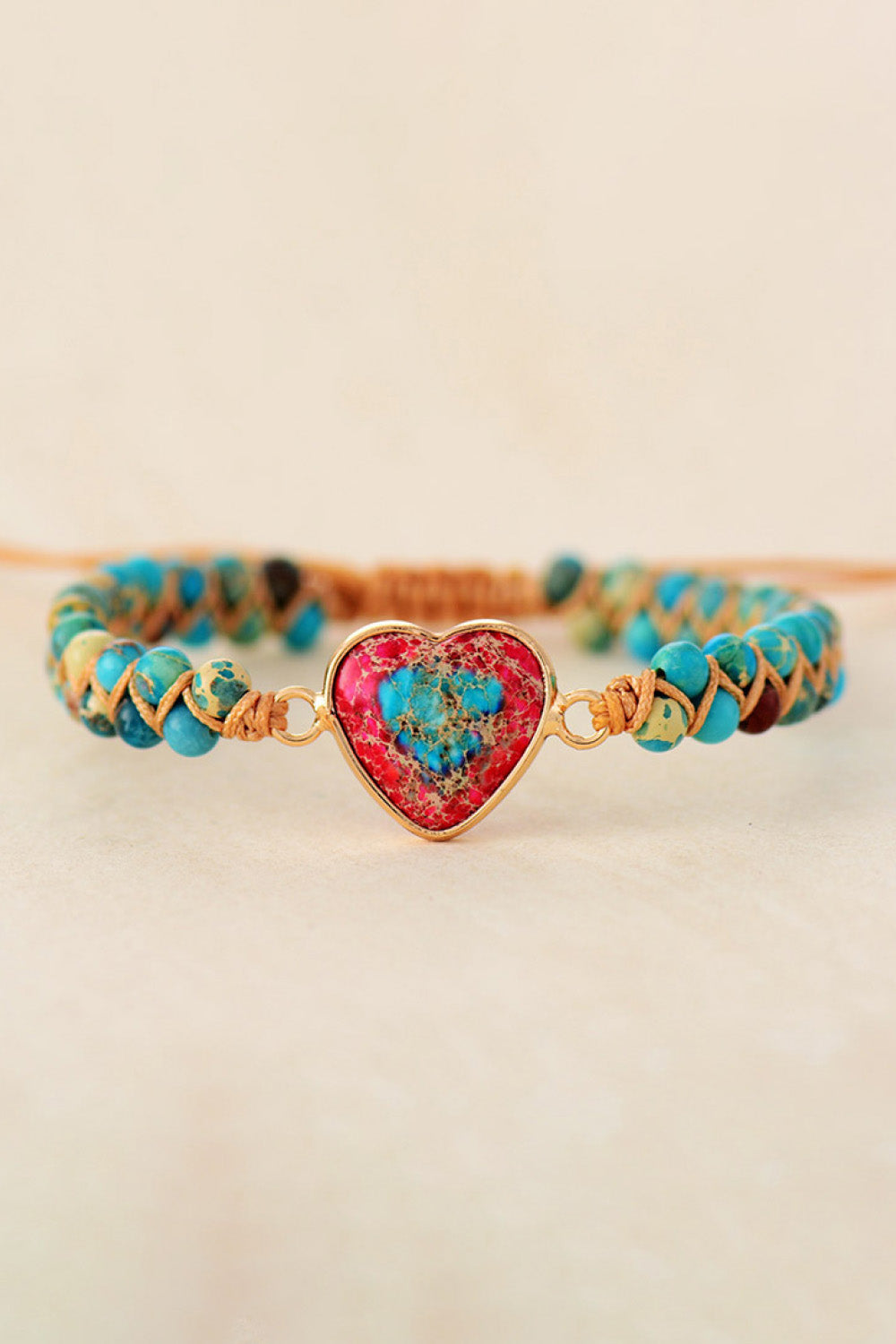 Heart stone beaded bracelet with blue and red stone centerpiece and gold accents.