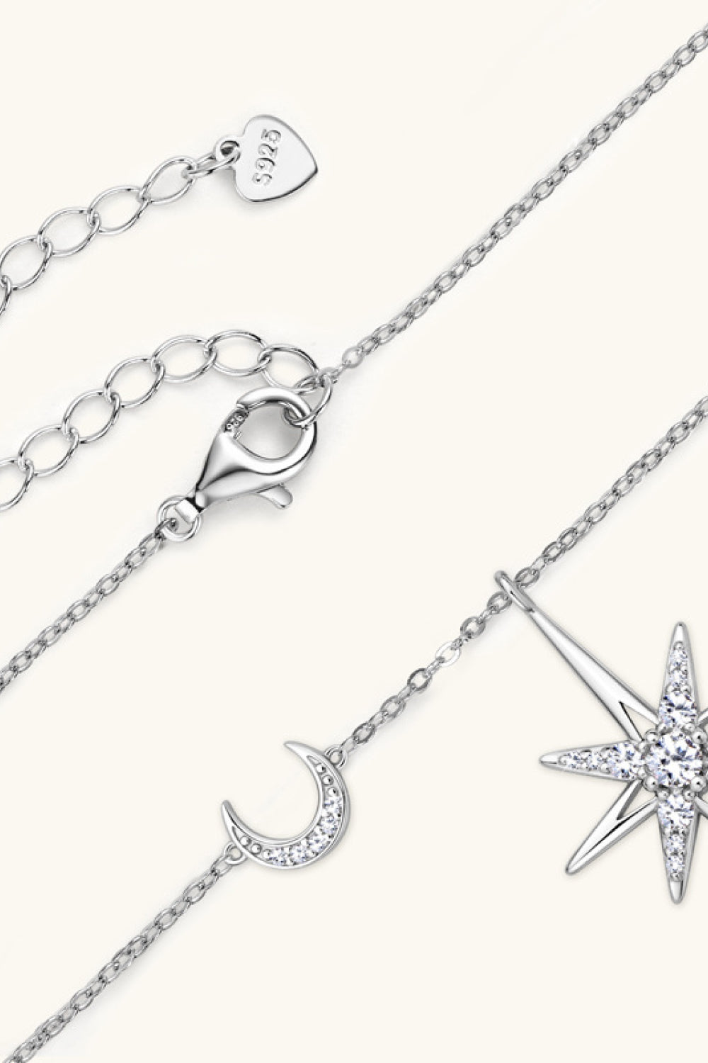Silver celestial starburst and crescent moon pendant necklace with cubic zirconia details.