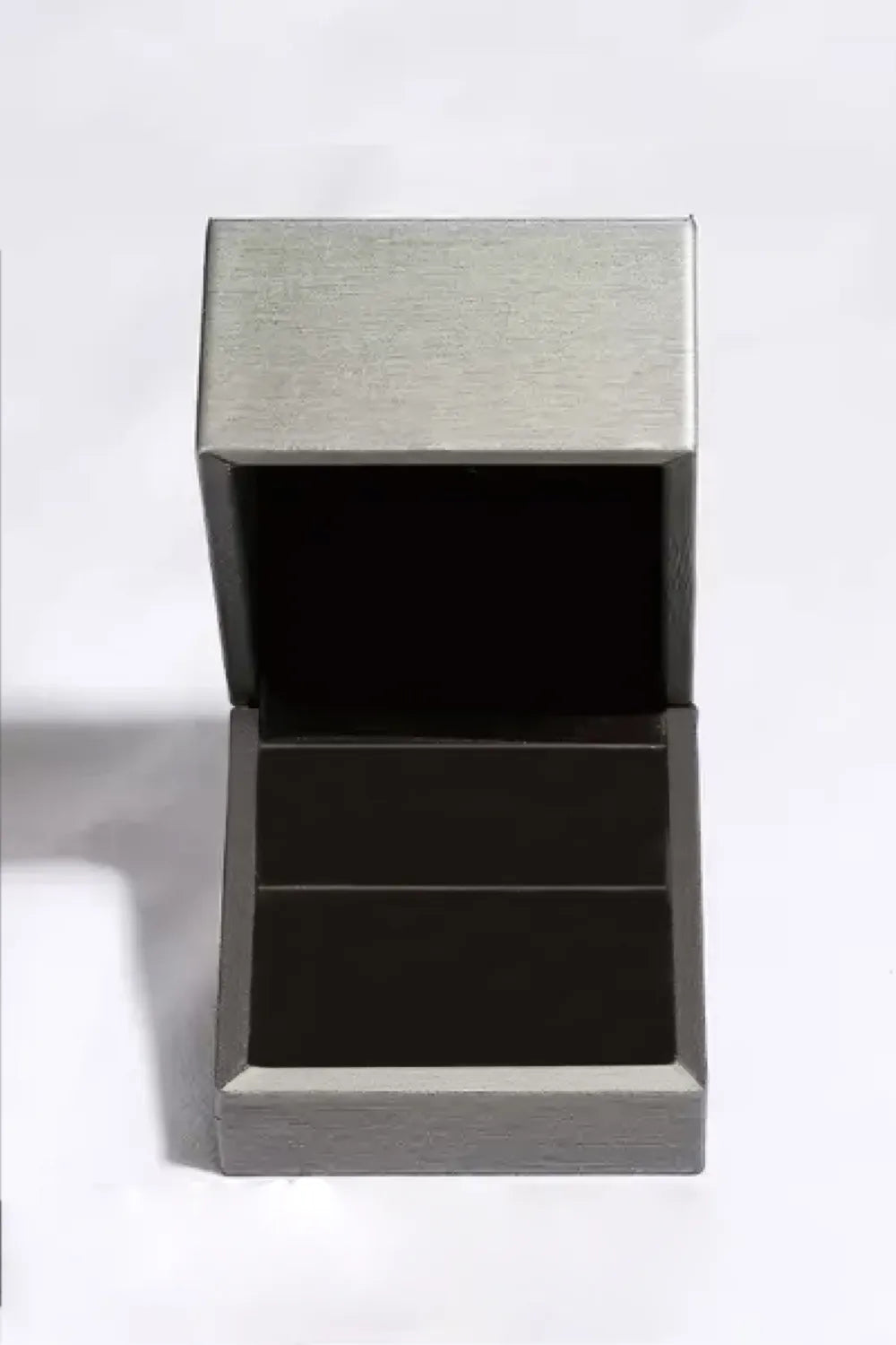Silver ring box with open lid and dark interior