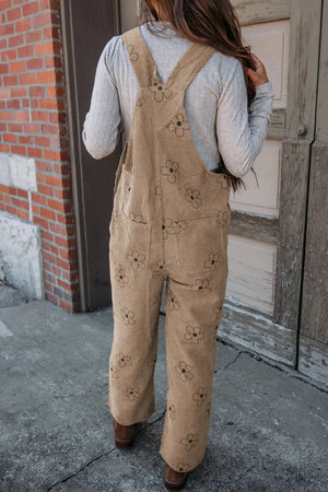 Khaki corduroy overalls with a floral print and relaxed fit.
