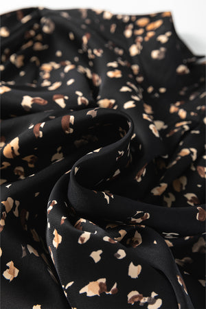 Black abstract print blouse with a high neckline.