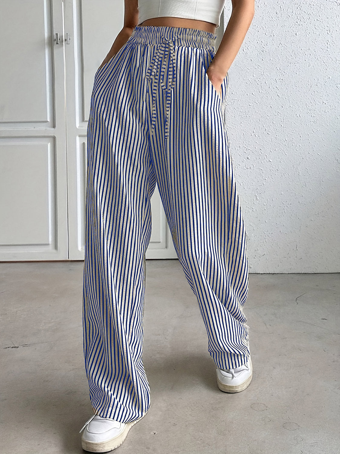 Blue and white striped wide-leg trousers with drawstring waist and pockets.