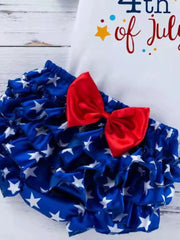 Ruffled baby bloomer shorts with white stars on blue, adorned with a red bow.