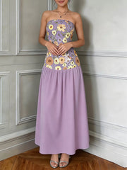Strapless maxi dress in Pink Purple with floral embroidery on bodice and a flowing skirt.
