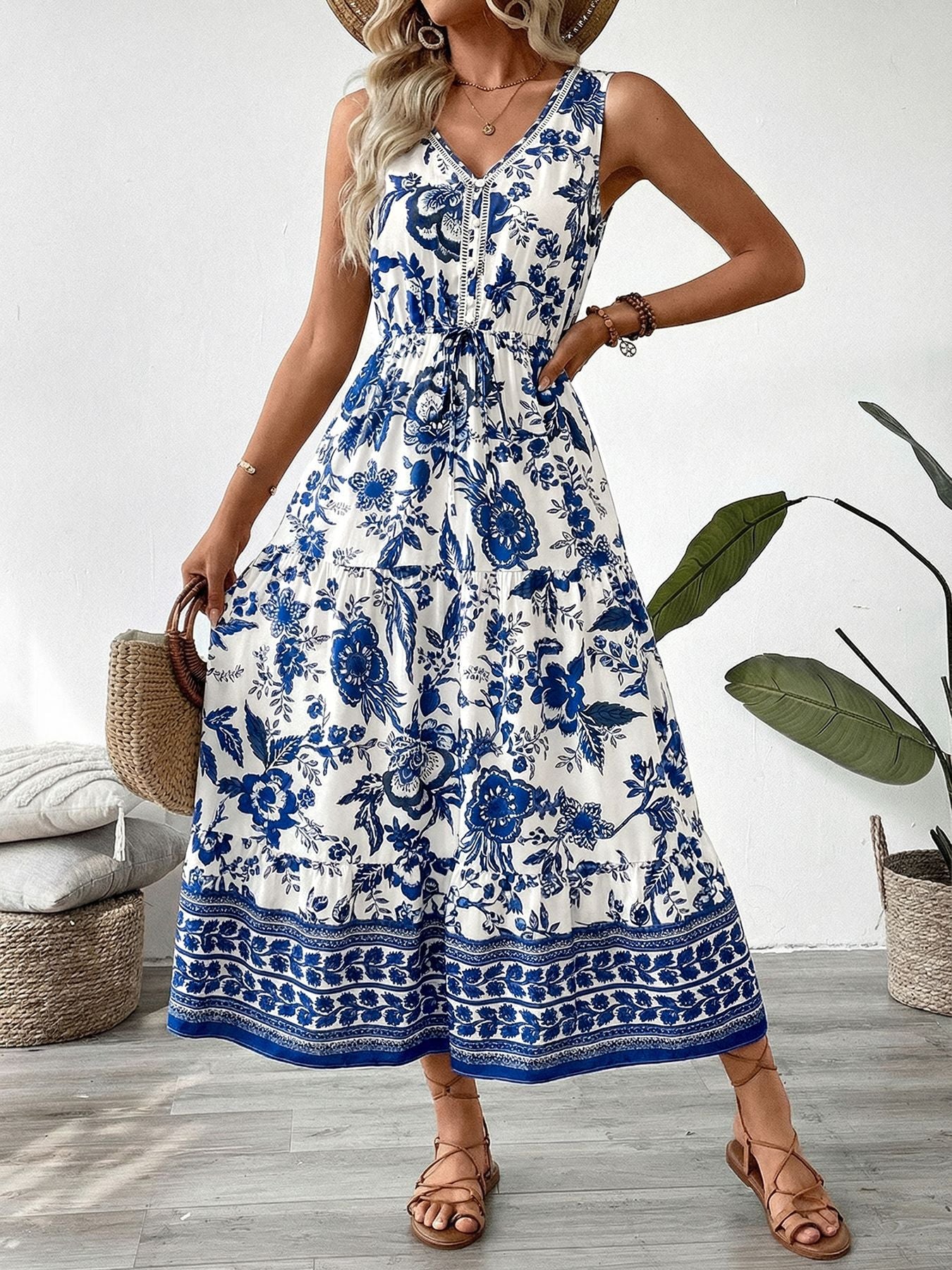 Midi dress with blue floral print, V-neck, drawstring waist, tiered skirt, and button-down detail.