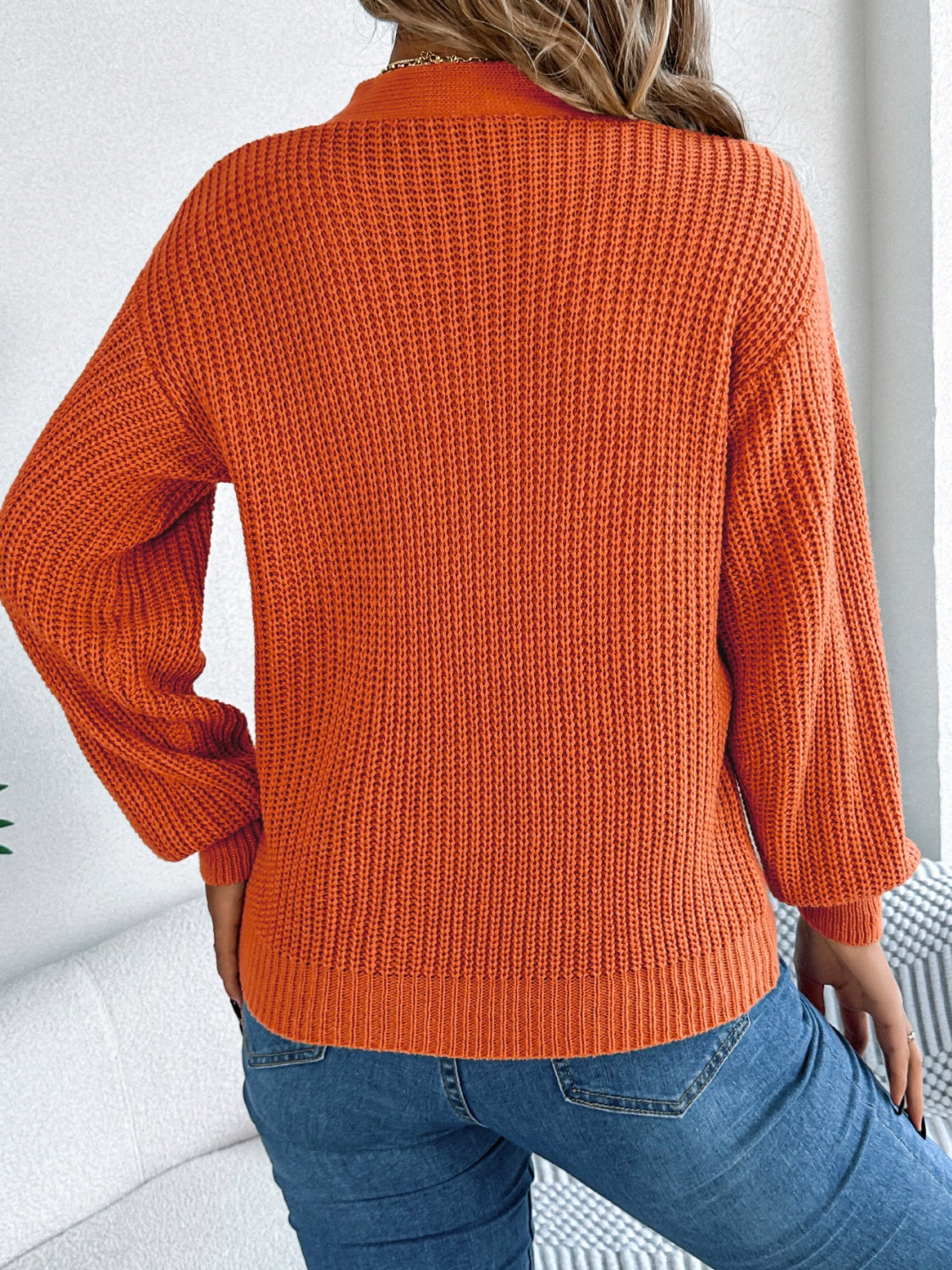 Terracotta cable knit sweater with crew neck and long sleeves, casual acrylic knit.