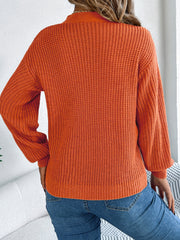 Terracotta cable knit sweater with crew neck and long sleeves, casual acrylic knit.