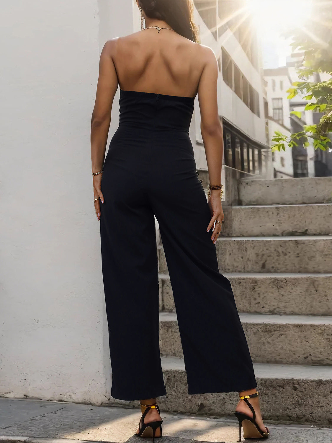 Black strapless bandeau palazzo jumpsuit with wide legs.