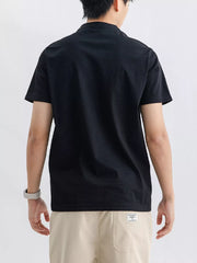 Men's black cotton short sleeve t-shirt with a band collar, shown from the back.
