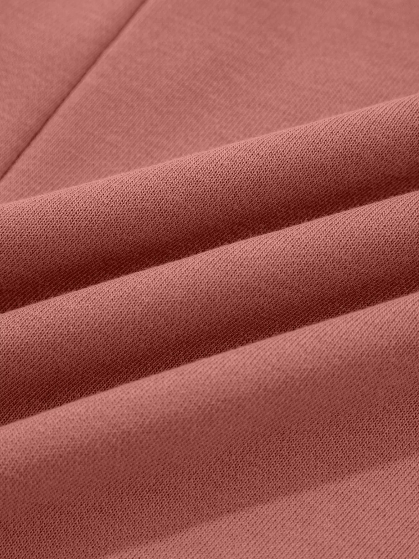 Dusty pink sweatshirt with exposed seam detail and textured fabric.