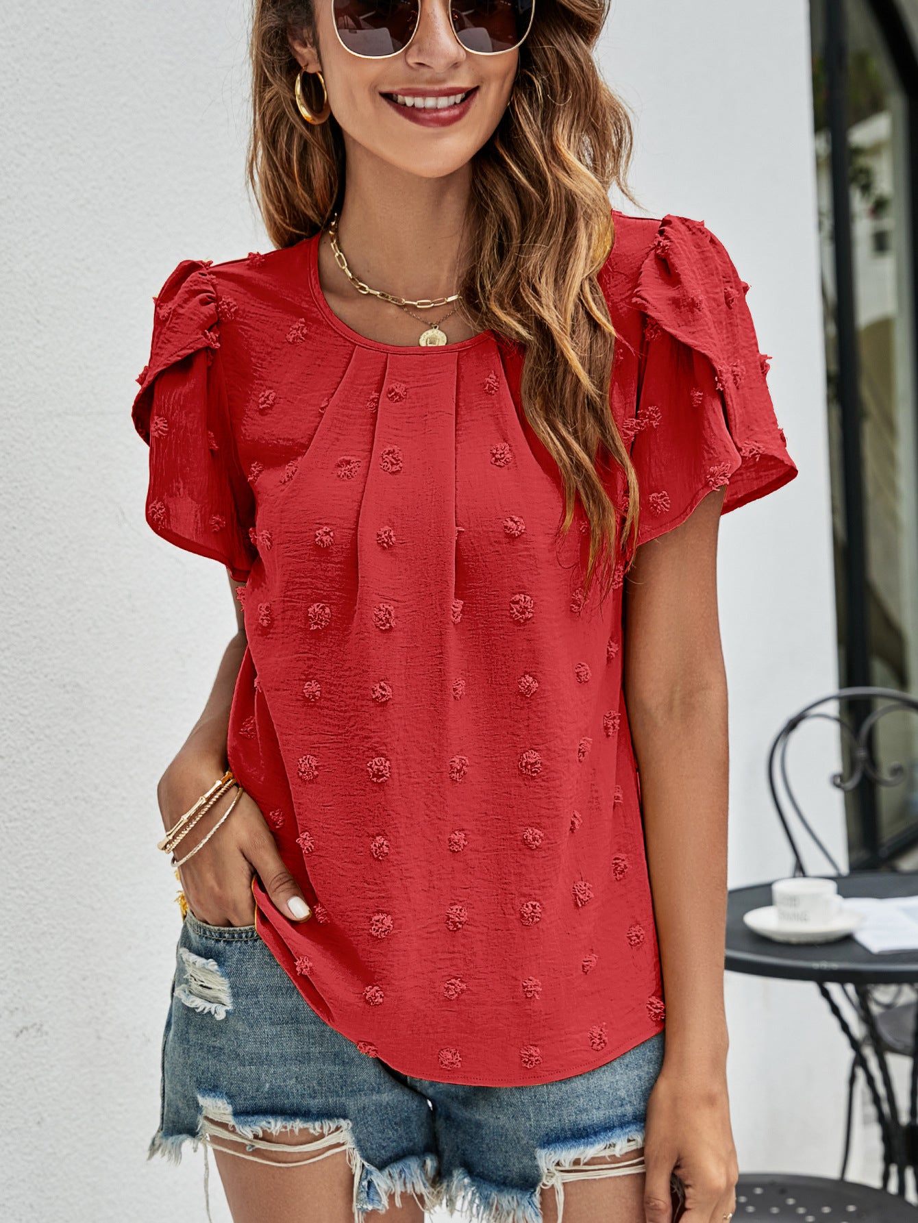 Red textured puff sleeve blouse with dot pattern and gathered neckline.