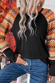Black raglan tee with Aztec print sleeves in tangerine, orange, and cream.