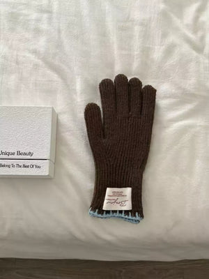 Brown ribbed knit gloves with scalloped blue cuff detail and white label