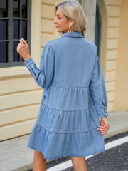 Tiered denim shirtdress in medium wash with buttoned cuffs and gathered tiers.