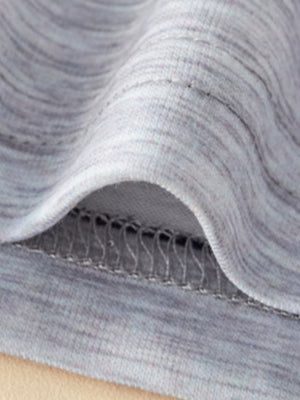 Close-up of grey marled cotton fabric with visible stitching detail on a baby outfit.