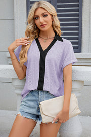 Lavender perforated polo top with black V-neck detail and short sleeves.