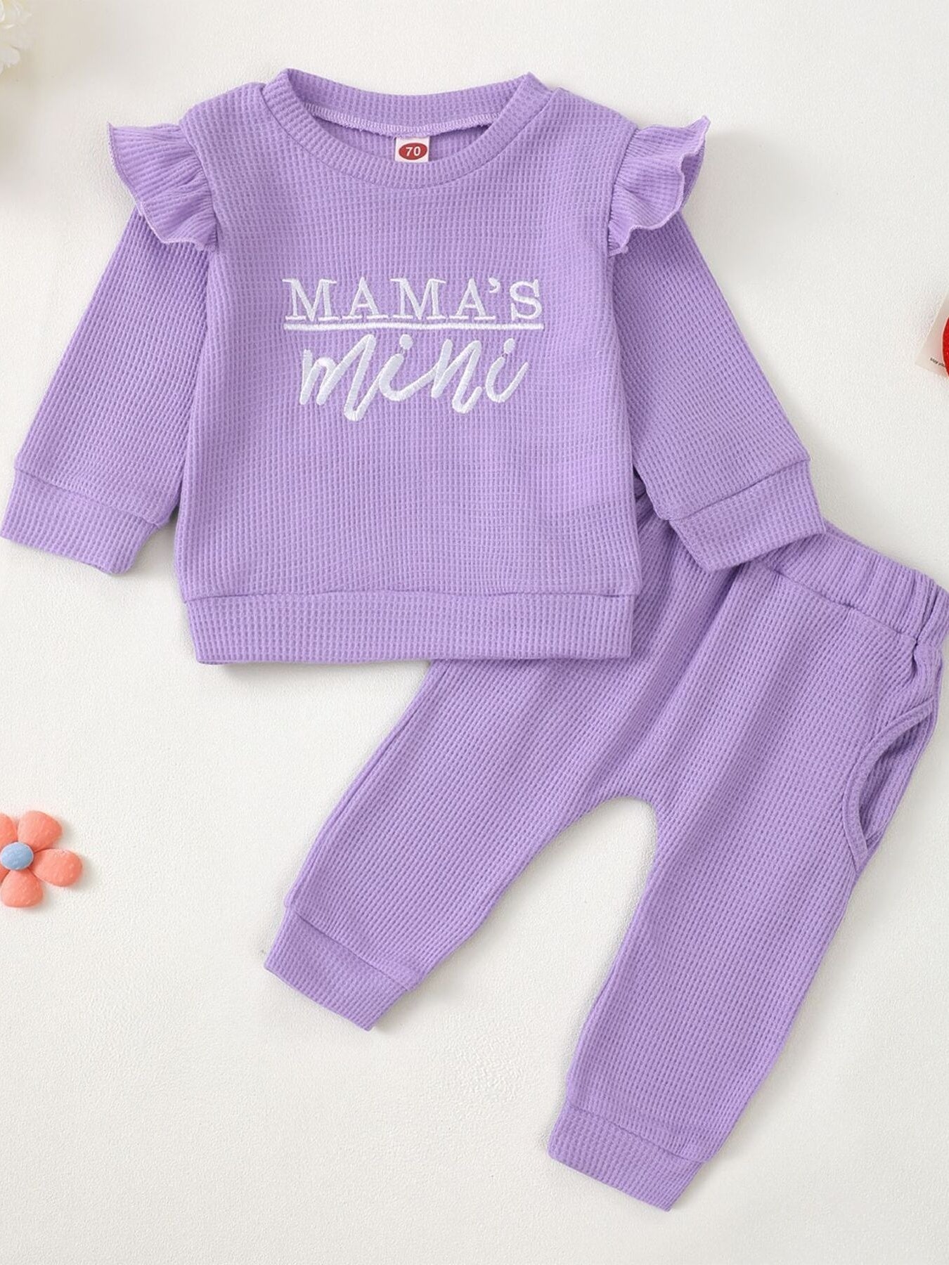 Purple waffle knit toddler top with ruffled sleeves and "Mama's Mini" graphic, and matching pants.