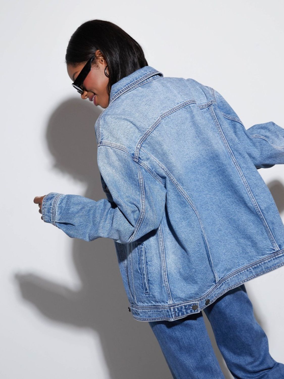 Denim trucker jacket in medium wash with collar and button details.