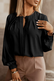 Black pleated yoke blouse with button detail and long sleeves