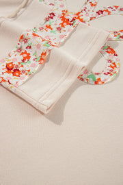 Ivory sweatshirt with floral appliqué raglan sleeves and crew neck detail.