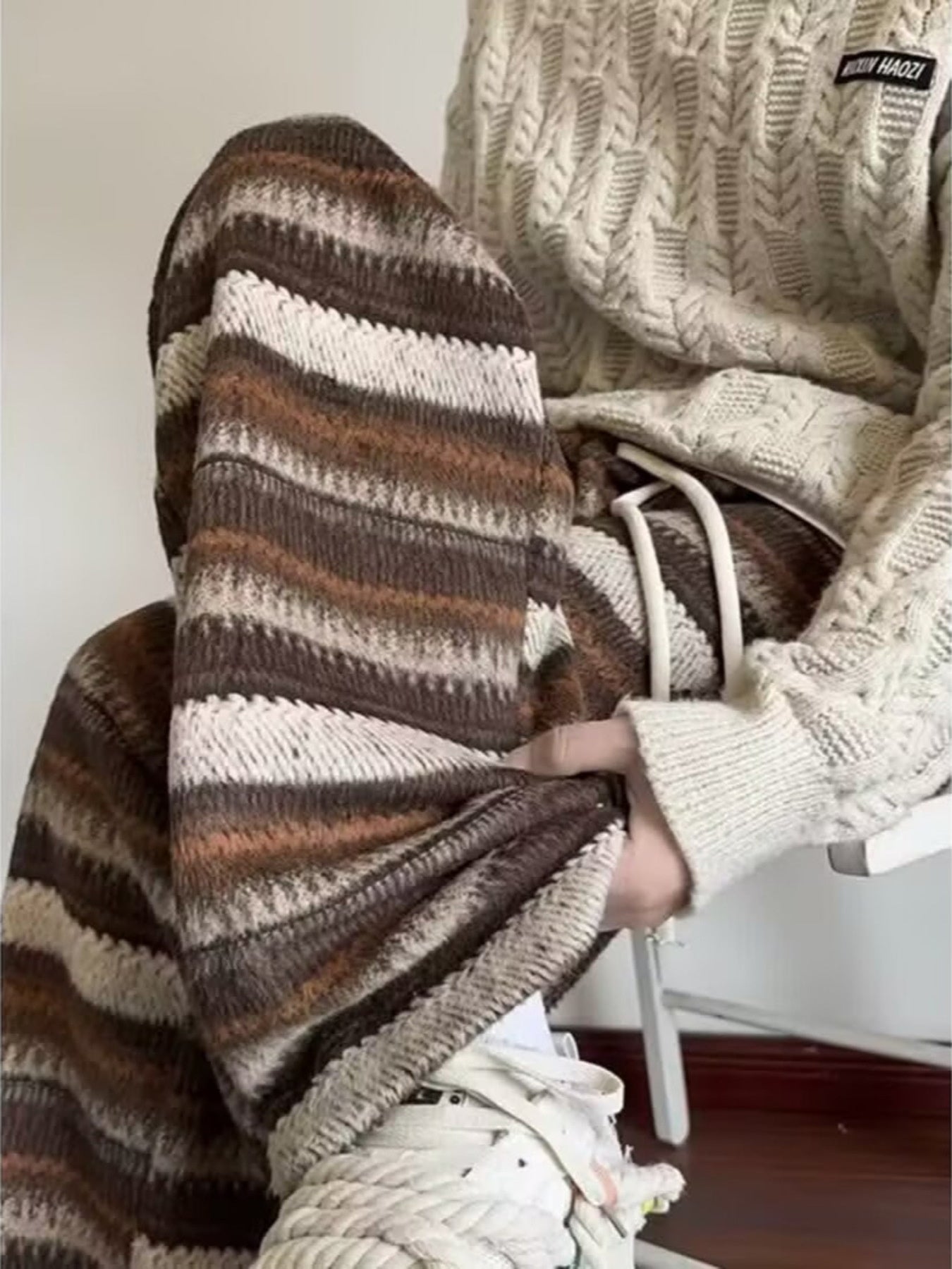 Men's brown and white striped wide-leg pants with drawstring waist.
