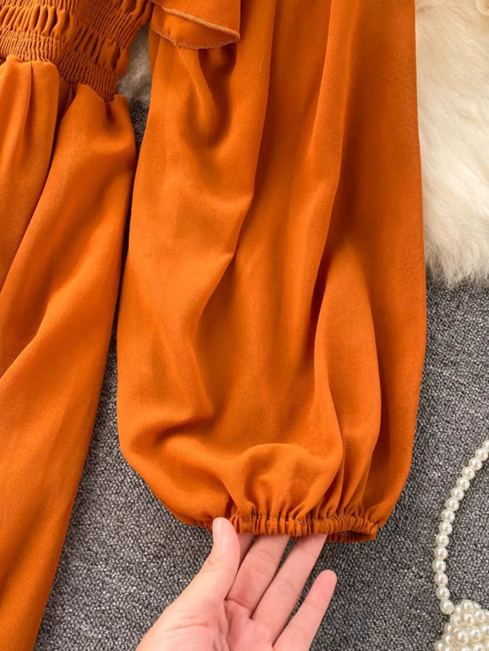 Orange maternity dress with smocked bodice, ruffled square neck, and balloon sleeves with elastic cuffs.