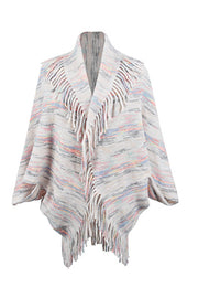 Textured knit cape with fringe trim and multi-color stripes.