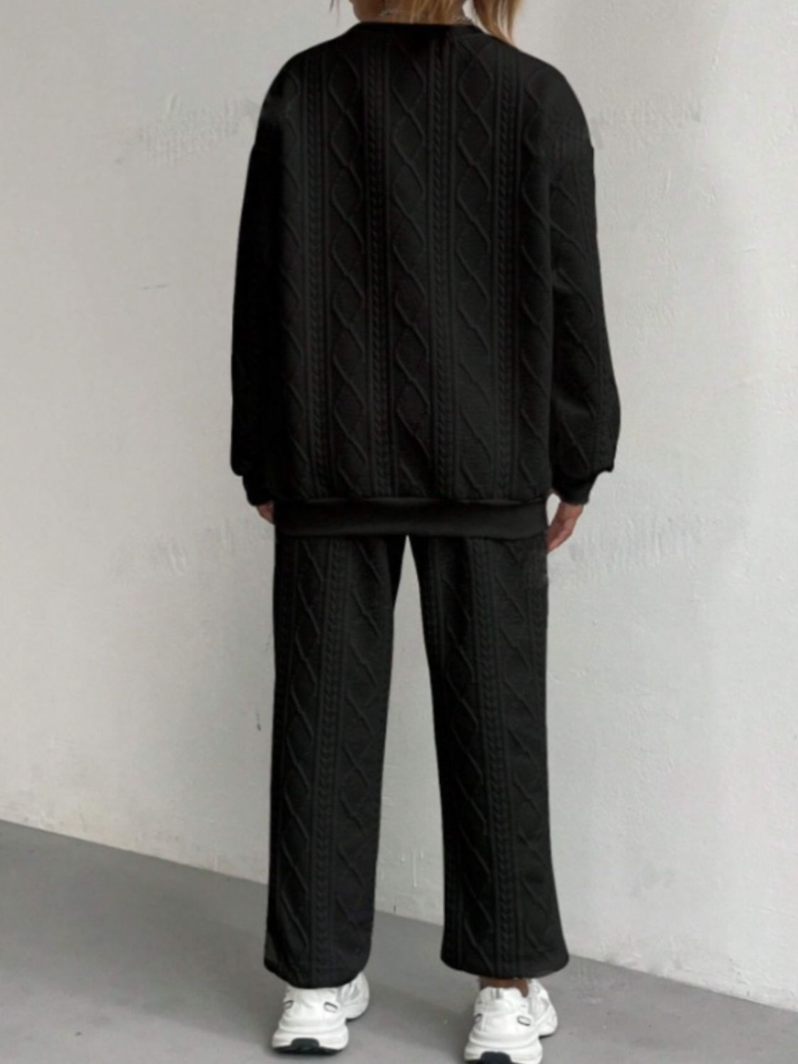 Black cable knit loungewear set with textured pattern, crewneck sweatshirt and wide-leg pants.