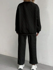 Black cable knit loungewear set with textured pattern, crewneck sweatshirt and wide-leg pants.