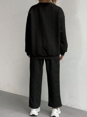 Black cable knit loungewear set with textured pattern, crewneck sweatshirt and wide-leg pants.