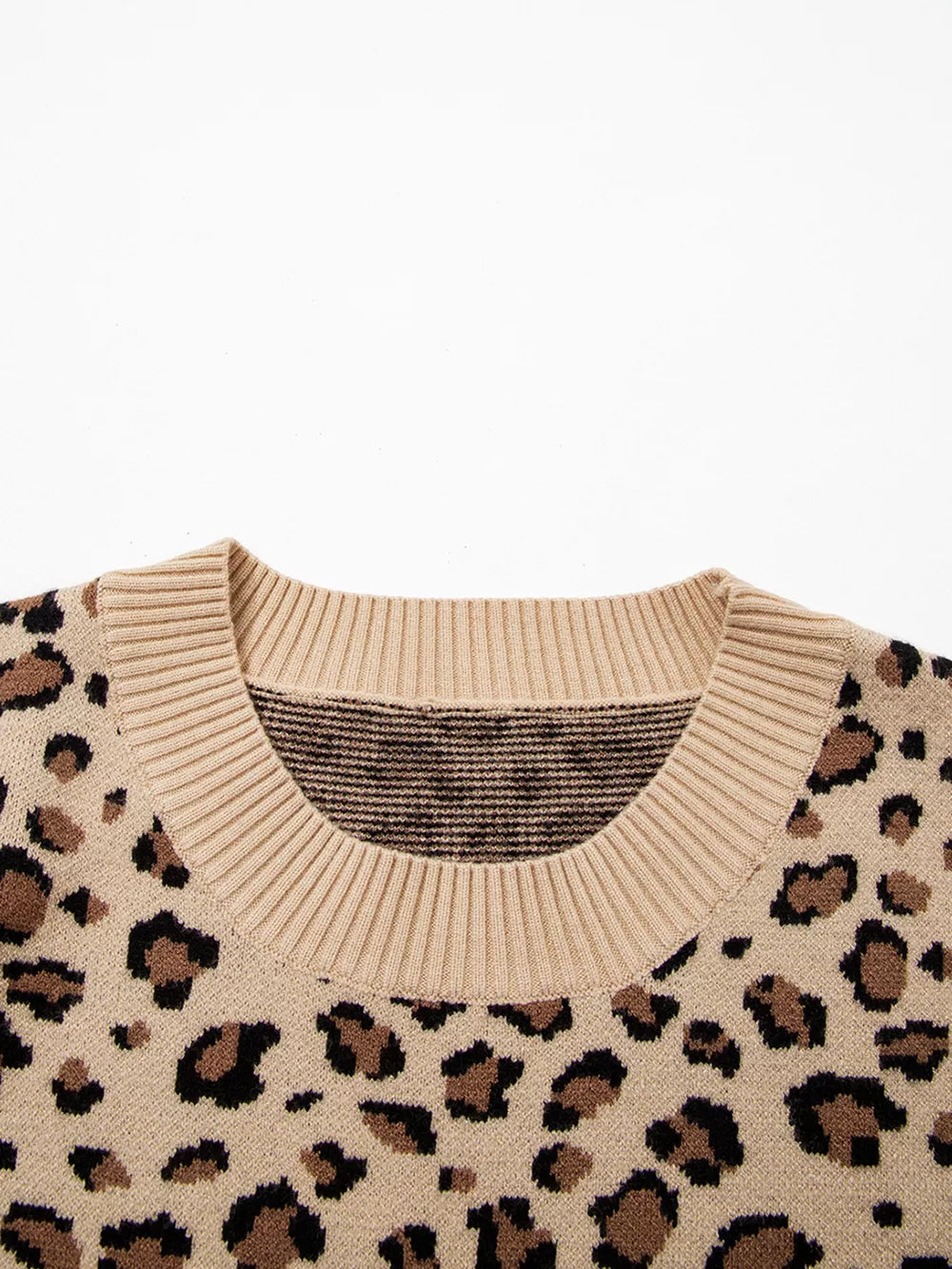 Beige leopard print knit sweater with crew neck and ribbed trim.