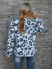 Sky blue leopard print blouse with blouson sleeves and henley neckline.