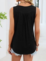 Black ruched tank top with button detail and curved hem, worn with denim shorts.