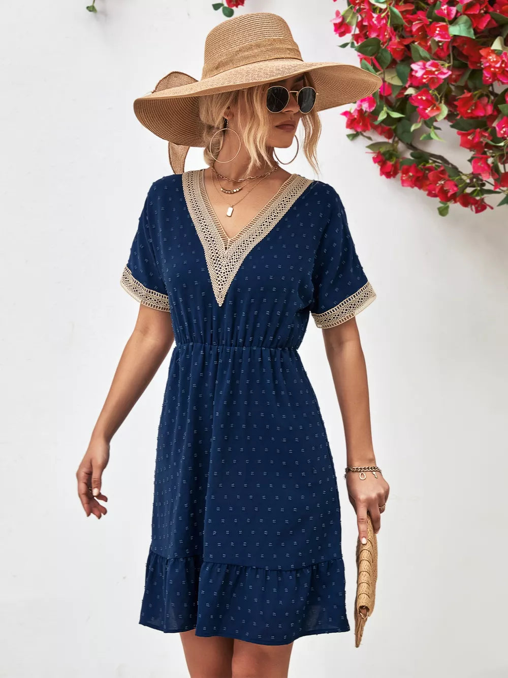 Navy Swiss dot mini dress with V-neck, lace trim, and ruffled hem.