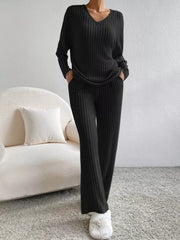 Black ribbed knit V-neck loungewear set with long sleeves and flared pants.
