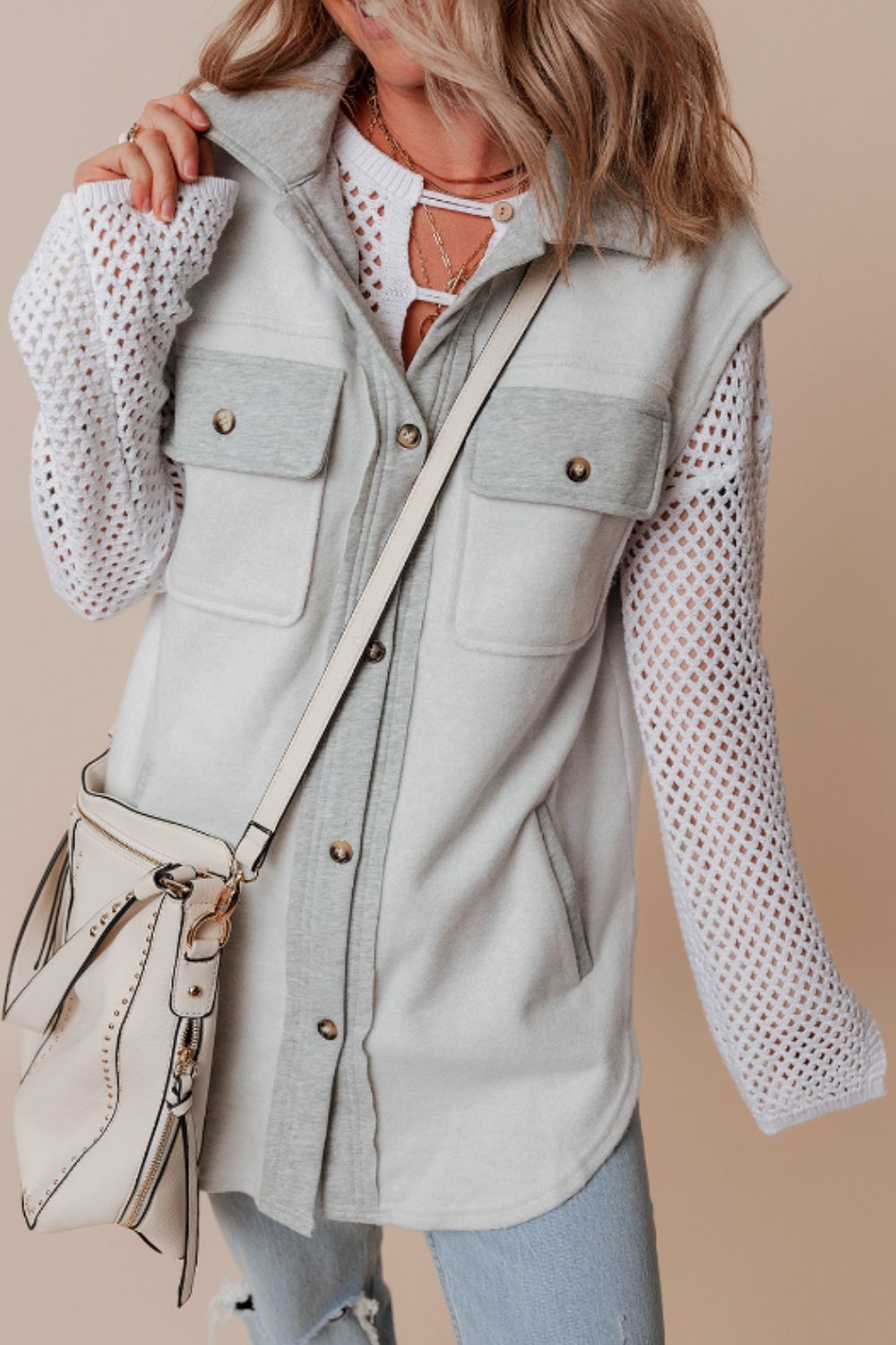 Light gray contrast trim utility vest with button-down front and chest pockets.
