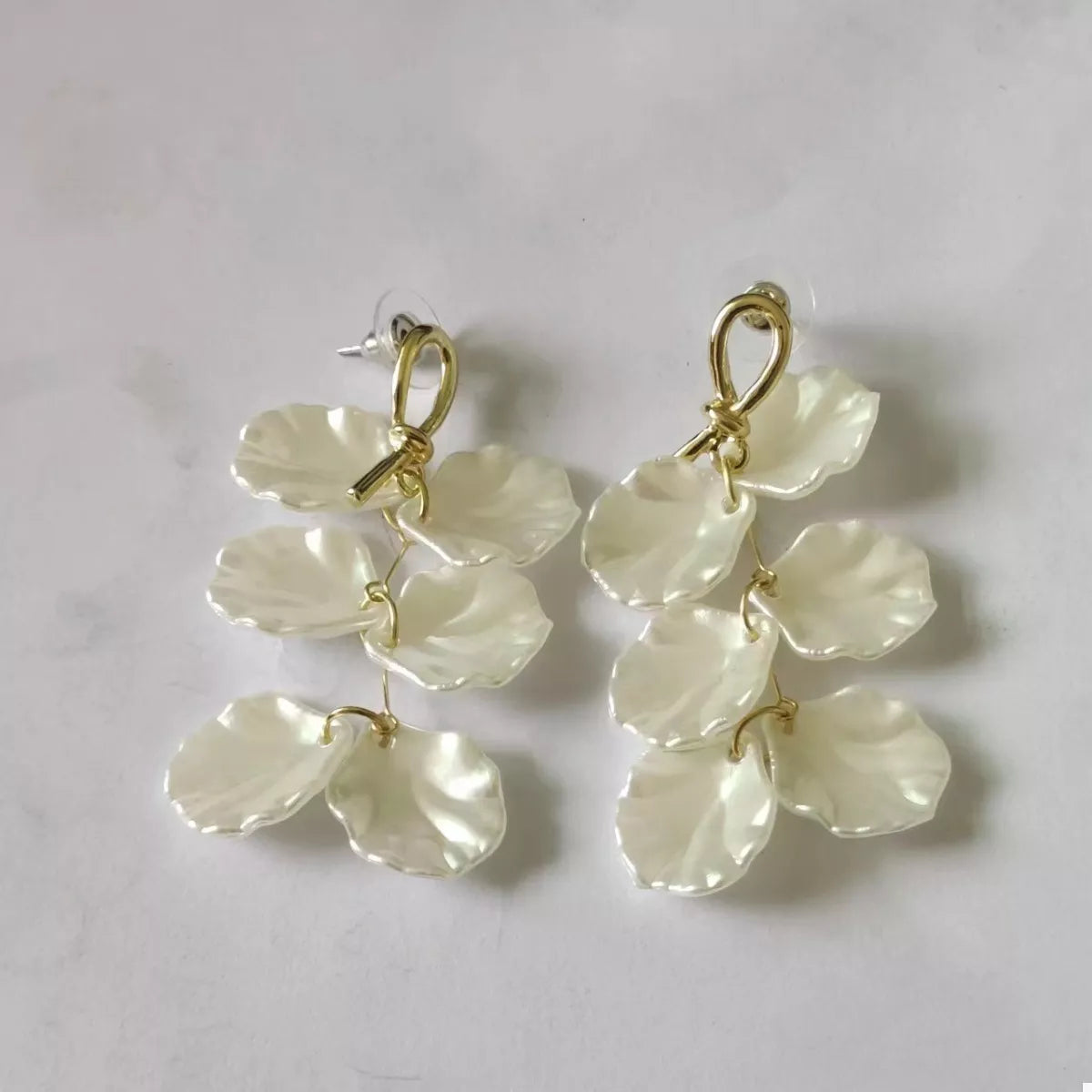 Elegant beige shell drop earrings with gold accents.