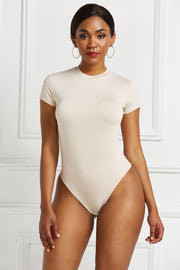 Sculpted crew neck bodysuit in Ivory with short sleeves and a high-cut leg.