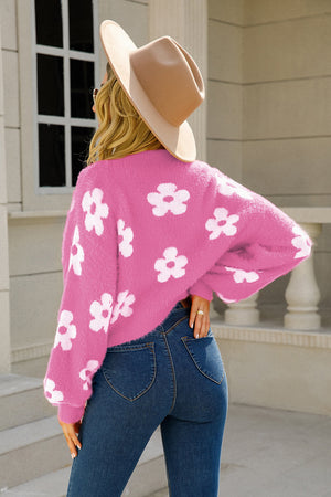 Fuchsia fuzzy cropped cardigan with white floral print and long sleeves.
