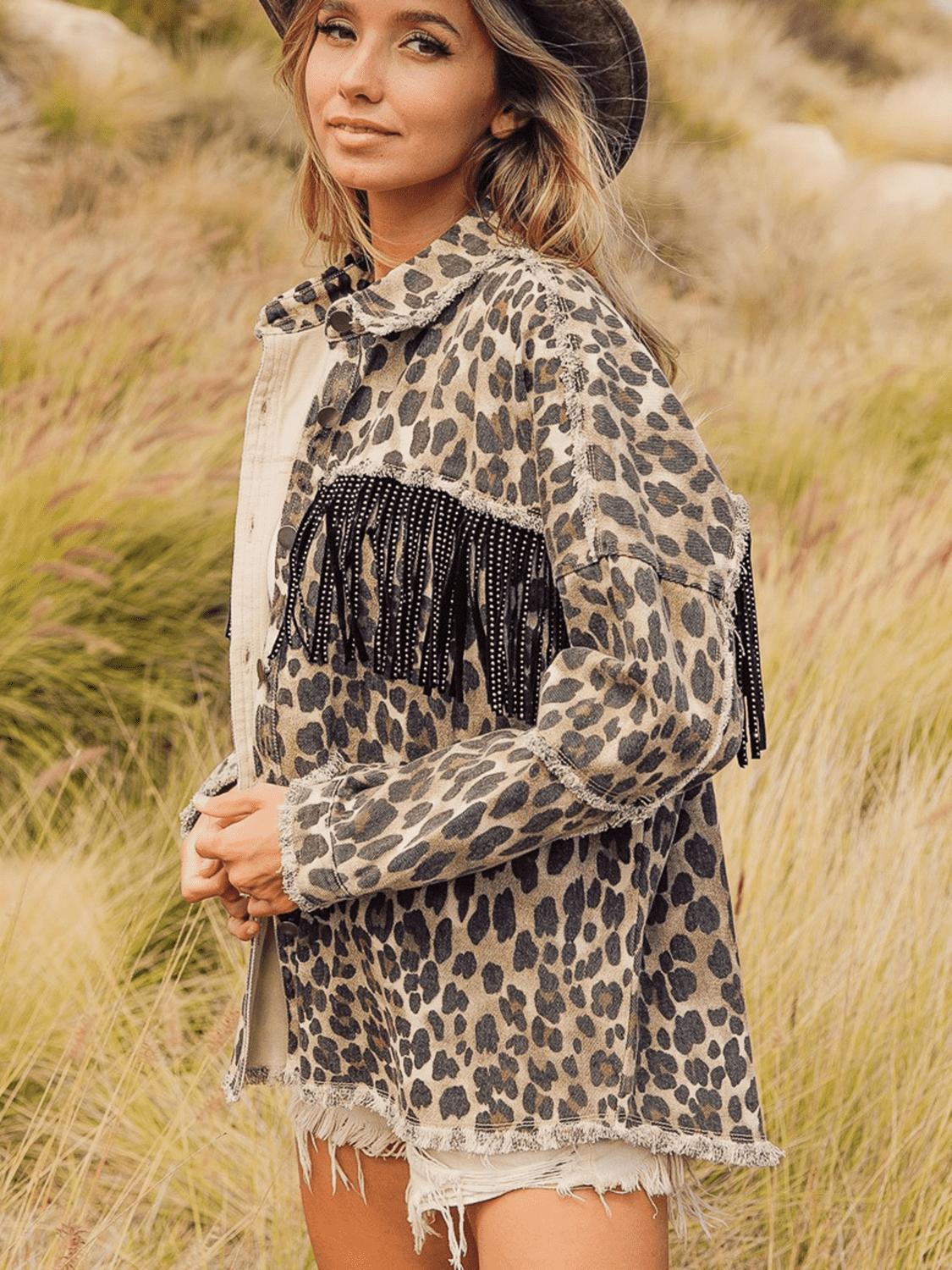 Leopard print denim jacket with black fringe embellishments and a collared neck.