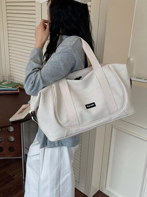 Off-white nylon travel duffle bag with curved stitching and adjustable strap.